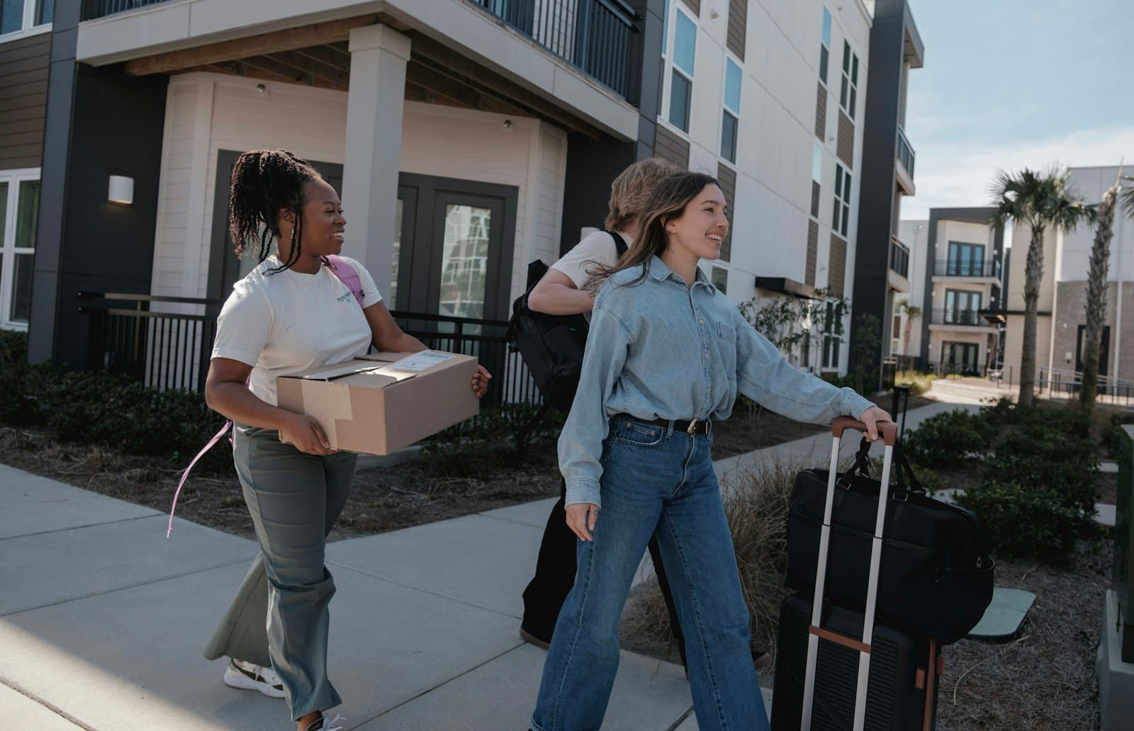 Friends helping each other carry boxes on moving day